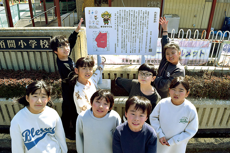 陣屋跡の看板を紹介する3年生8人＝久喜市立栢間小