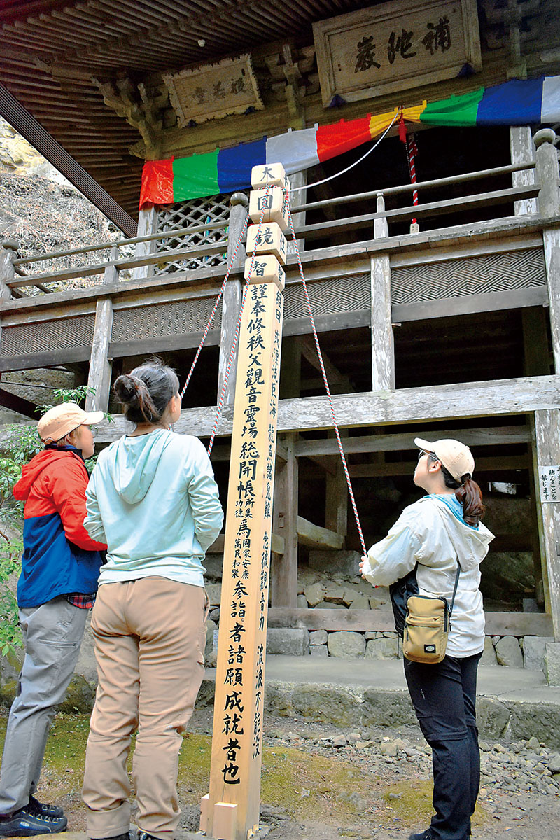祈願塔の御手綱に触れ、観音様と縁を結ぶ参拝客