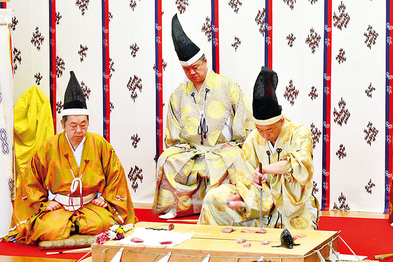 コイをたちどころに切り身にする包丁人（右）＝22日正午ごろ、秩父神社