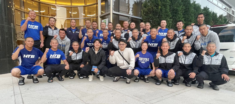 若月健矢選手(前列中央)、楠本泰史さん(同左から4人目)と記念写真を撮る花咲徳栄の選手たち(同校硬式野球部提供)