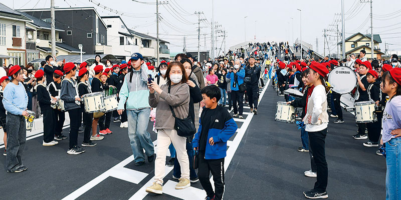 渡り初めをして白岡宮代線の開通を祝う市民ら＝22日午後、白岡市の白岡中央大橋