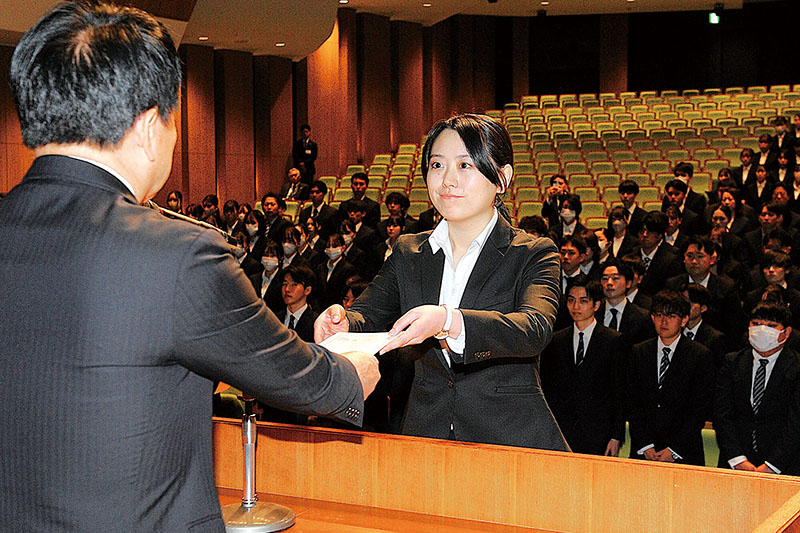 清水勇人市長から、新規採用職員を代表して辞令を受け取る山田結衣さん＝1日午前、さいたま市大宮区のレイボックホール