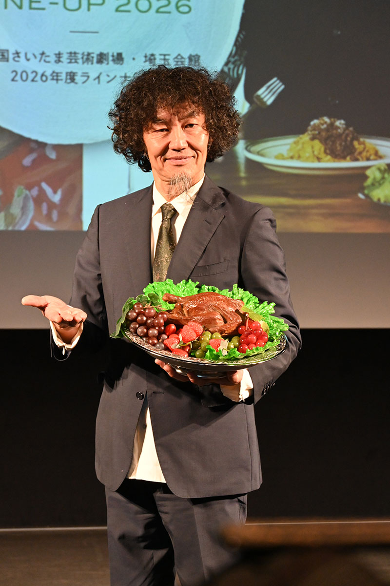 小道具の盆を手にポーズをとる芸術監督の近藤良平さん