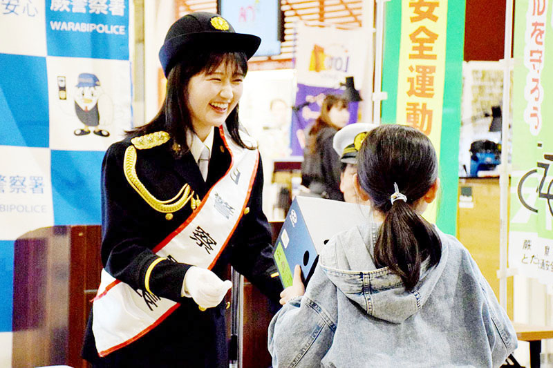 交通安全クイズの正解者に賞品を渡す須賀ありささん（左）