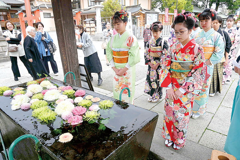 十三参りで、着物姿で手水の作法を学ぶ子どもたち＝3月31日、東松山市箭弓町の箭弓稲荷神社