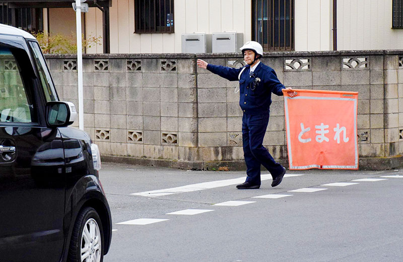 通学路で交通違反の取り締まりを実施する警察官