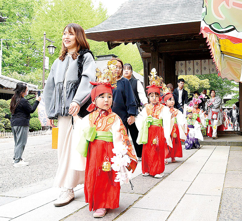 稚児行列で境内を練り歩く親子ら