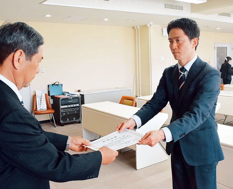 久喜市長選の当選証書を受け取る貴志信智氏＝20日午前、久喜市役所