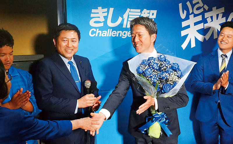 支援者から花束を受け取る貴志信智氏（右）＝20日午前0時20分ごろ、久喜市東5丁目の事務所