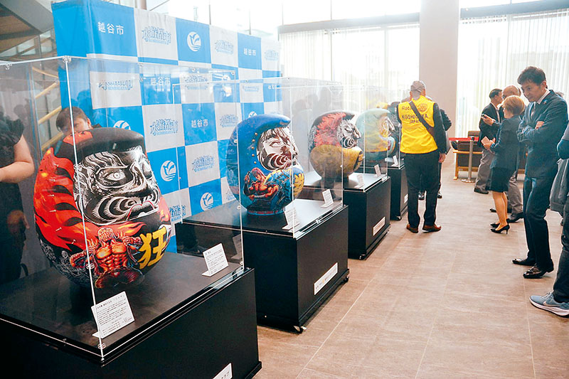 展示された「北斗の拳　越谷だるま」4体を見学する除幕式参加者＝21日、越谷市役所