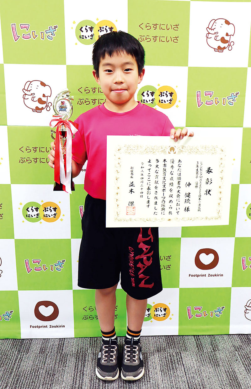 優勝トロフィーと並木傑市長から授与された市民表彰状を手に喜ぶ新座市立東北小学校4年の仲健琉さん