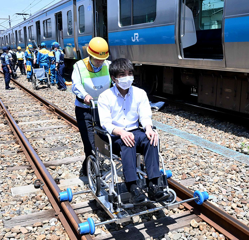 搬送台車を使って車いすを移動させる様子