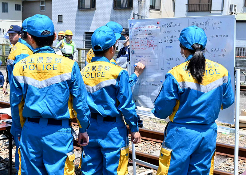 現地指揮所で状況確認をする警察官ら
