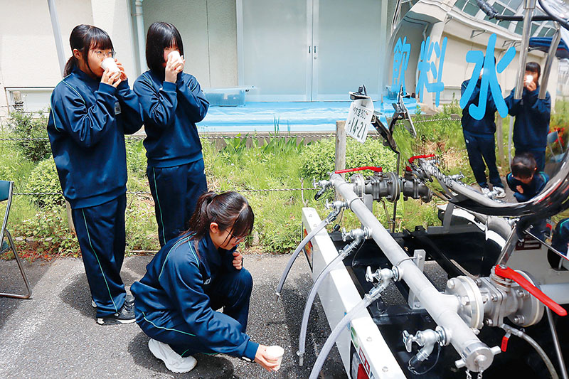 災害派遣用給水車の飲料水を試飲するボランティアの中学生たち＝上尾市立尾山台小学校