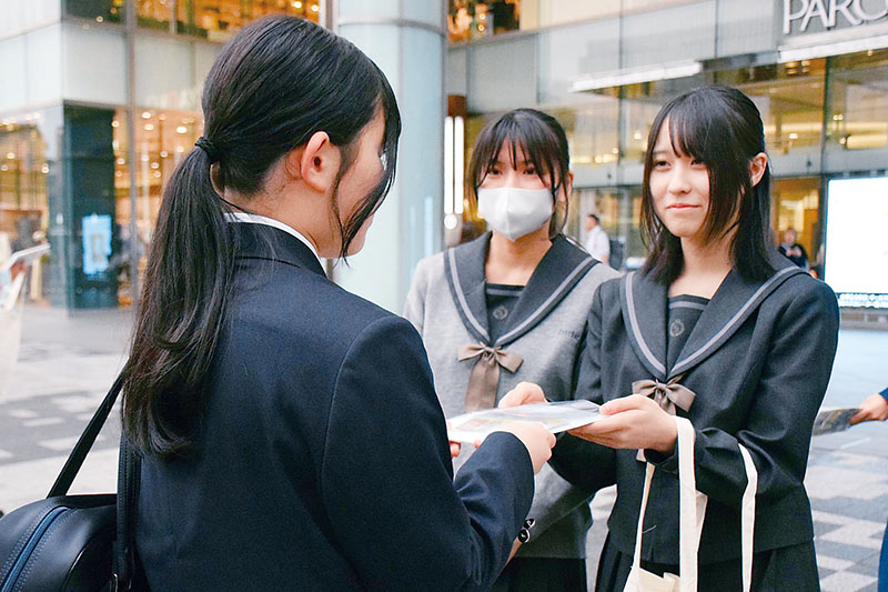 性暴力被害防止の啓発品を配布する浦和麗明高校の生徒（奥）
