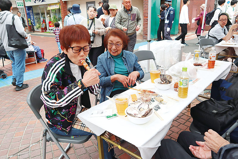 上尾串ぎょうざを味わう市民ら＝JR上尾駅西口モンシェリー通り