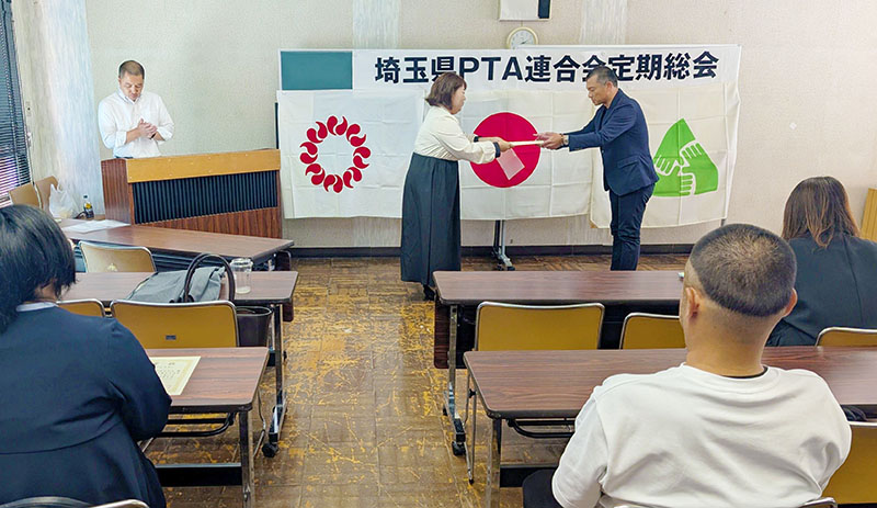 最後の事業となった広報紙コンクール表彰式で船橋会長から表彰状を受け取る熊谷市立熊谷東中学校のPTA代表者（右）