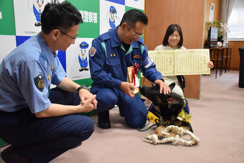 丸山精一郎署長（左）から感謝状を受け取った羽鳥文仁さん（中央）と羽鳥牧子さん、おもちゃをもらったおはぎ号＝22日午後、さいたま市緑区の浦和東署