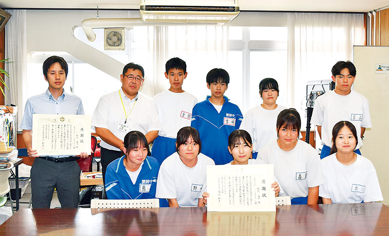 人命救助に貢献し、感謝状を受け取った生徒たちと新宅凌平教諭（左上）＝19日、市立葛飾中学校