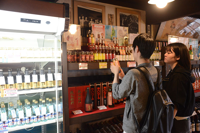お酒を選ぶ観光客＝23日午後、秩父市宮側町の武甲酒造