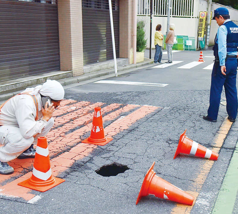 さいたま市浦和区仲町3丁目の市道で発見された道路の陥没＝28日午後6時半ごろ