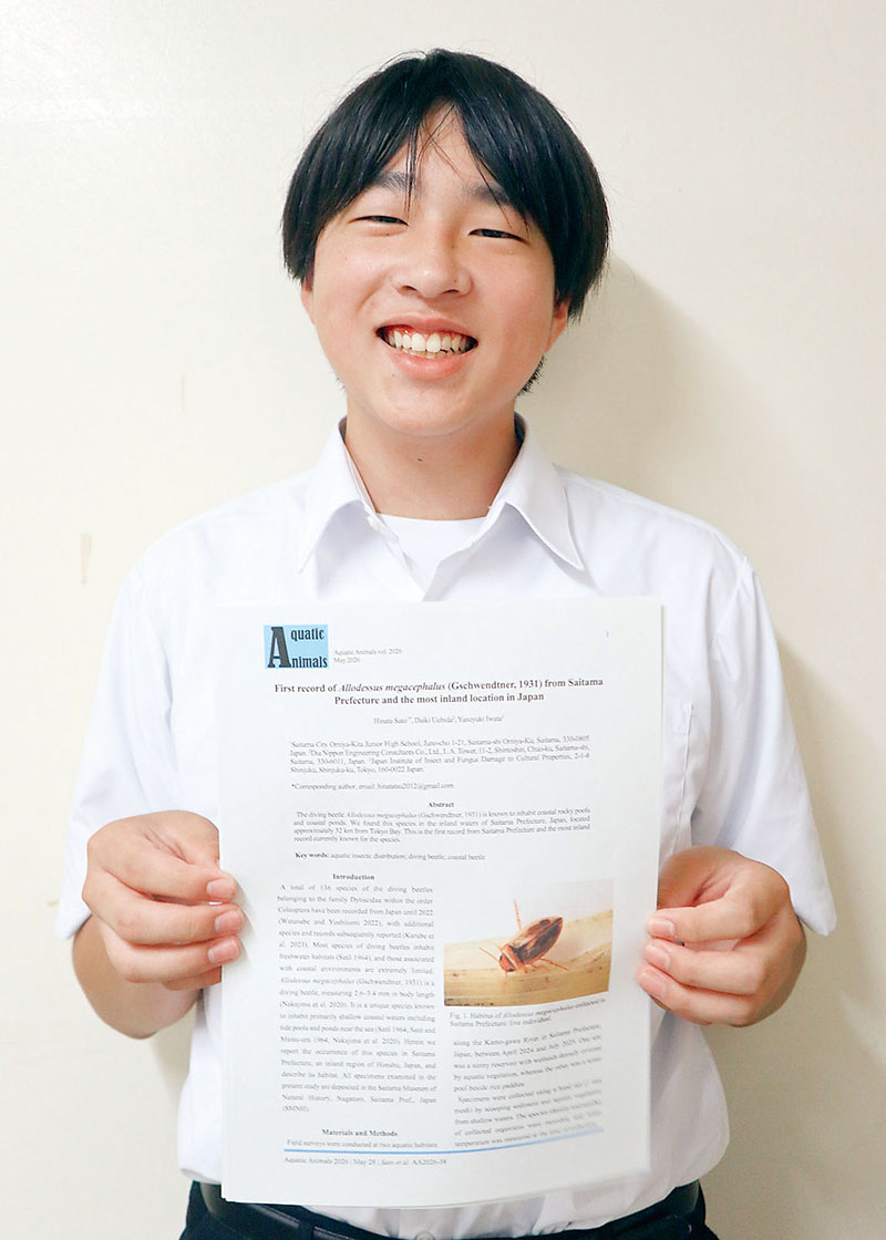 チャイロチビゲンゴロウの論文を手にする佐藤日向さん＝さいたま市大宮区の市立大宮北中学校