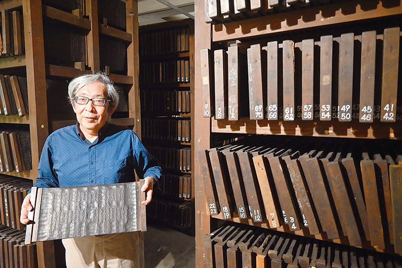 版木倉庫で群書類従の版木を手にする温故学会代表理事の斉藤幸一さん＝東京都渋谷区東2丁目の温故学会会館