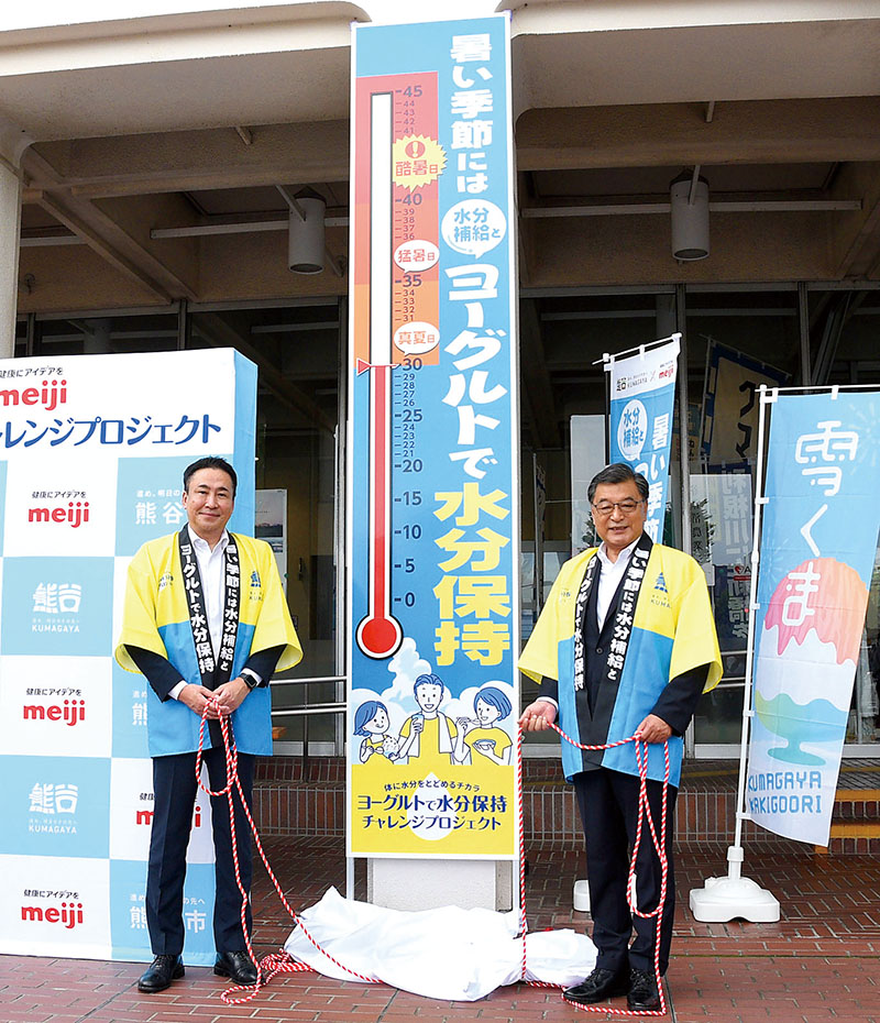 共同プロジェクトで製作した大温度計を除幕する熊谷市の小林哲也市長（右）と明治の関慶次発酵マーケティング部長