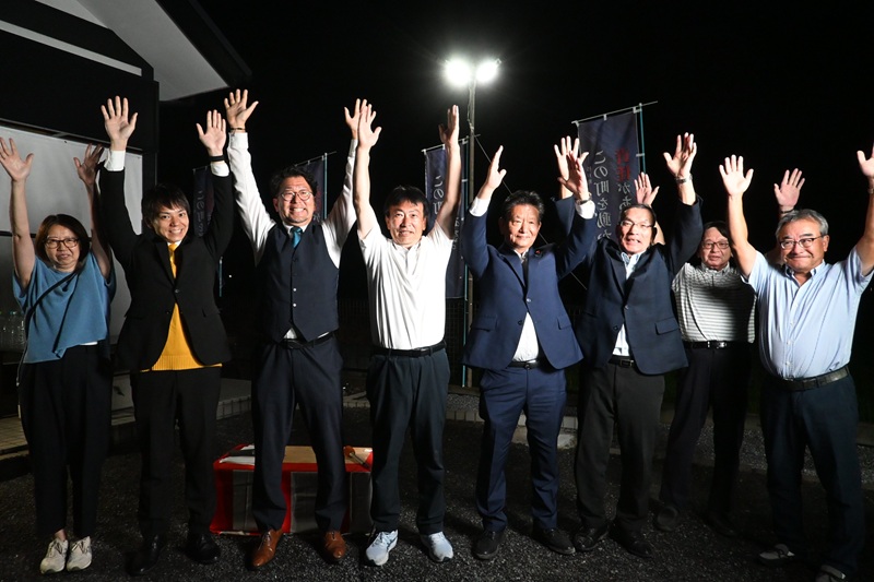 支援者とともにバンザイする窪田氏＝26日午後10時半ごろ、杉戸町下高野の選挙事務所