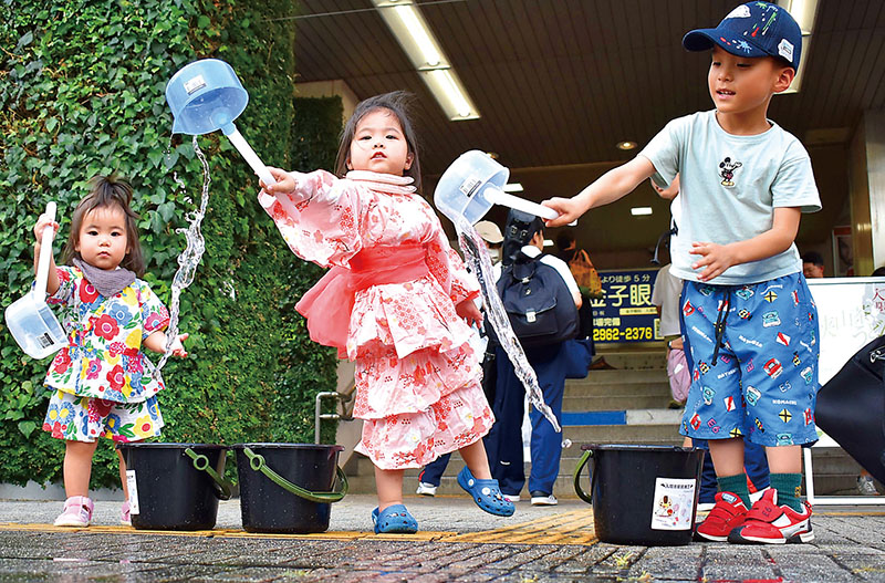 打ち水を楽しむ子どもたち