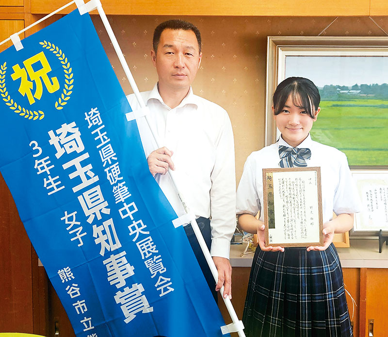 書道や硬筆の展覧会で最高賞を数多く受賞している野元柚那さん（右）と、吉田順一校長