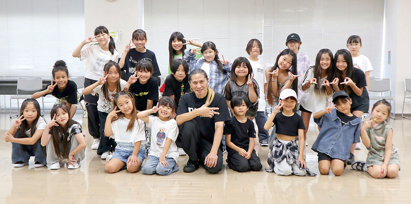 ダンスレッスンに参加した子どもたちと記念撮影をするSAMさん