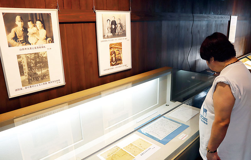 山田孝さんが妻に宛てた遺書や家族写真などの展示を見る来場者