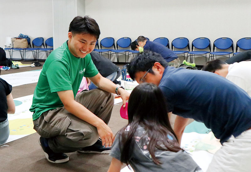救命講習会で参加者に胸骨圧迫の方法を教える桐田真さん（左）＝8月11日、さいたま市大宮区