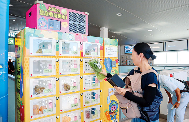 自販機のボックスから欲しいものを選んで買う消費者＝JR上尾駅自由通路西口エレベーター付近