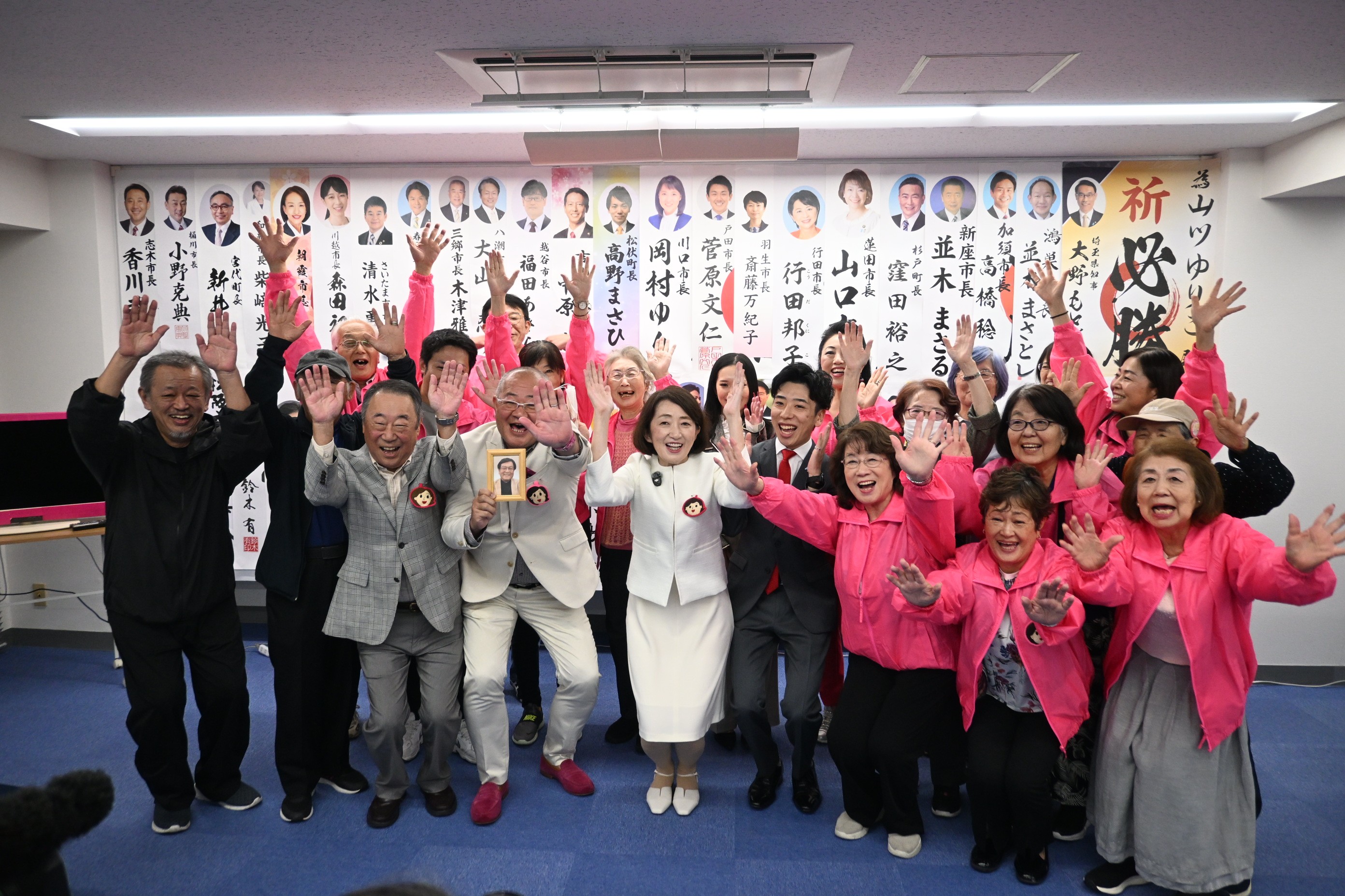 当選の報を受け支援者と喜ぶ山川百合子氏（左から2人目）＝19日午前0時15分ごろ、草加市高砂の選挙事務所