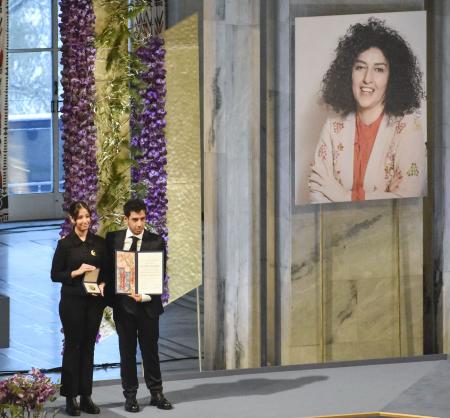 　１０日、ノーベル平和賞の授賞式でナルゲス・モハンマディさんに代わり賞を受け取った娘キアナさん（左）と息子アリさん＝オスロ（共同）