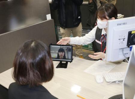 宮崎県都城市の郵便局で行われたマイナンバーカード交付の新規申請のデモンストレーション。市職員とビデオ通話で本人確認を行う＝２１日午前