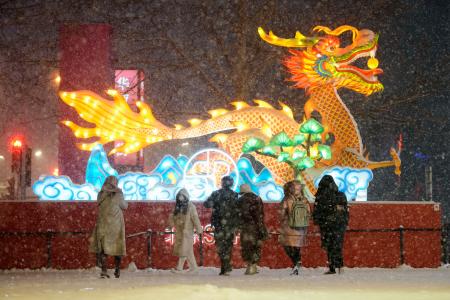 大雪が降る北京市内を歩く人たち＝２０日（共同）