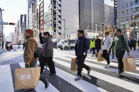 東京・銀座で買い物袋を手に歩く外国人ら＝１月