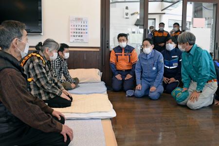 避難している家族から話を聞く岸田首相（右から３人目）＝２４日午前、石川県穴水町（代表撮影）