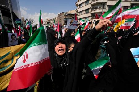 　１９日、テヘランで、イラン国旗を掲げながら反イスラエル集会に参加した人々（ＡＰ＝共同）