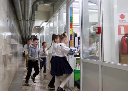 　ウクライナ東部ハリコフの地下鉄駅構内につくられた教室の廊下を走る子どもたち。教室や廊下には窓がない＝１５日（共同）