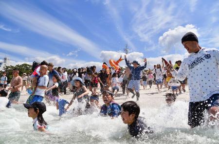 和歌山県白浜町の白良浜が海開きし、一斉に海へ駆け込む海水浴客＝３日午前