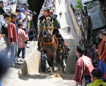 　三重県桑名市の多度大社で行われた、地元の青年が馬に乗って坂を駆け上がる「上げ馬神事」。高さ２メートルの土壁を撤去し、勾配を緩めるなど今年から大幅に様式を変更した＝４日午後