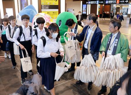 福井駅の構内で、首都圏から訪れた中学生を見送る富山、石川、福井３県の関係者ら＝１６日午後