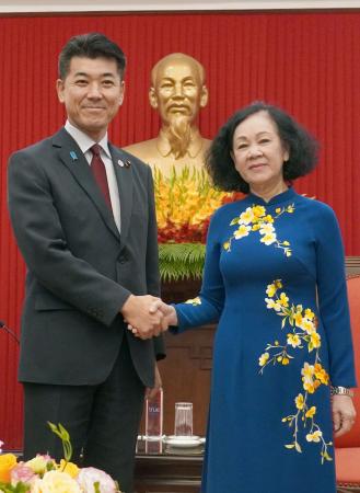 昨年８月、ベトナムの首都ハノイで立憲民主党の泉代表（左）と握手するチュオン・ティ・マイ氏（共同）