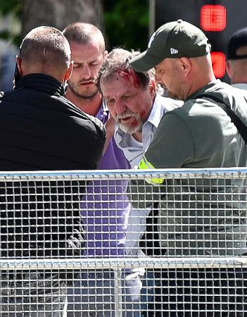 １５日、スロバキアのフィツォ首相が銃撃された中部ハンドロバで、身柄を拘束される人物（右から２人目）（ロイター＝共同）