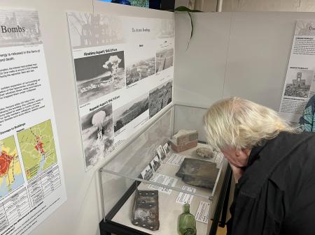 １２日、米ハワイ・真珠湾の戦艦ミズーリ記念館で始まった「原爆・平和展」で、展示資料を見る来場者（共同）