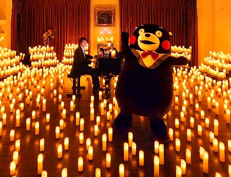 菅野大地さんのピアノ演奏に合わせ、指揮を練習するくまモン＝７月、熊本県内（同県提供）